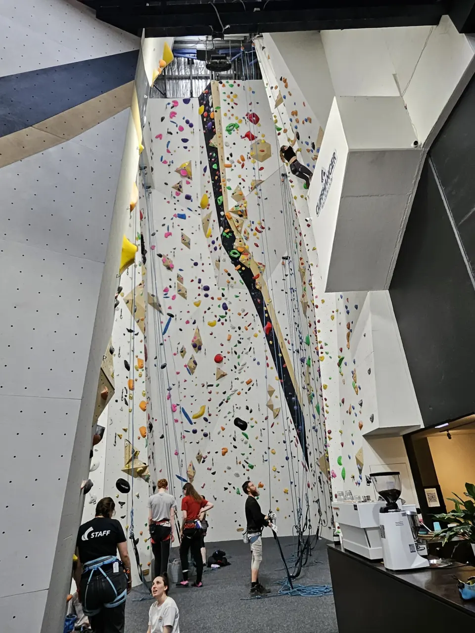 Climbers gearing up below the 19-metre walls, next to the reception coffee machine