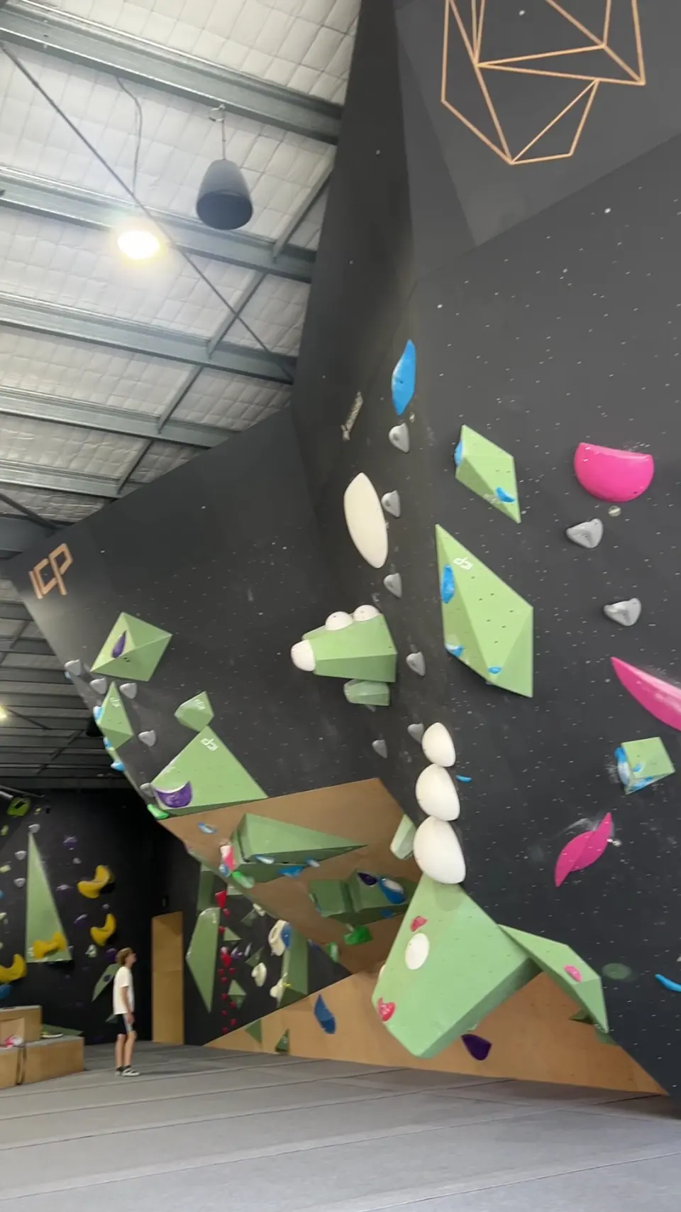 Tall dark wall with green and pink holds