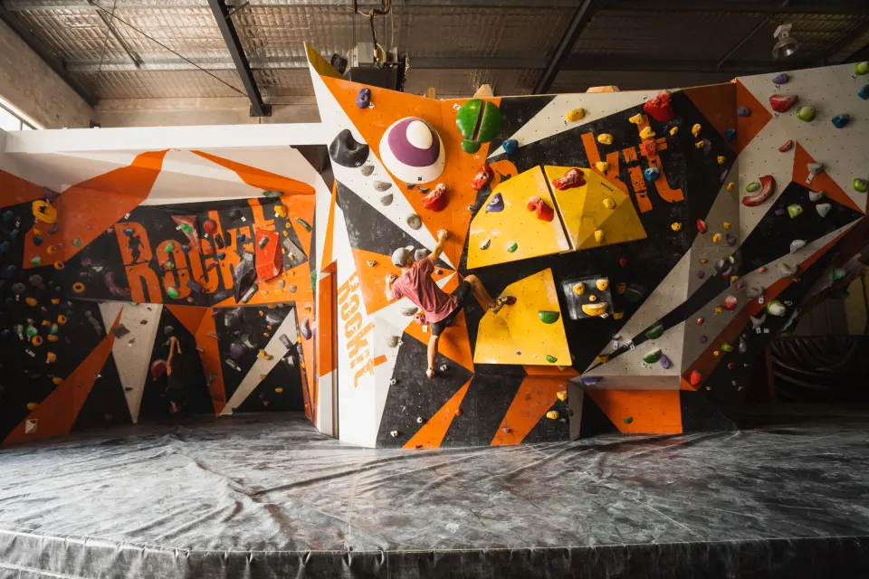 Bouldering wall painted with the Rockit name in orange, black and yellow