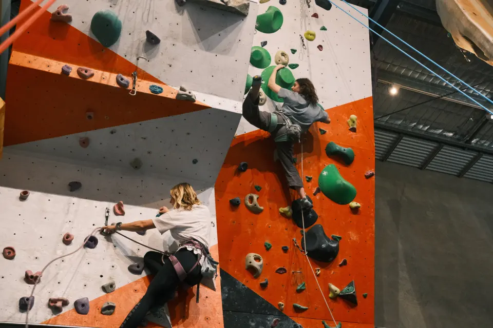 Two climbers on the orange and white roped walls