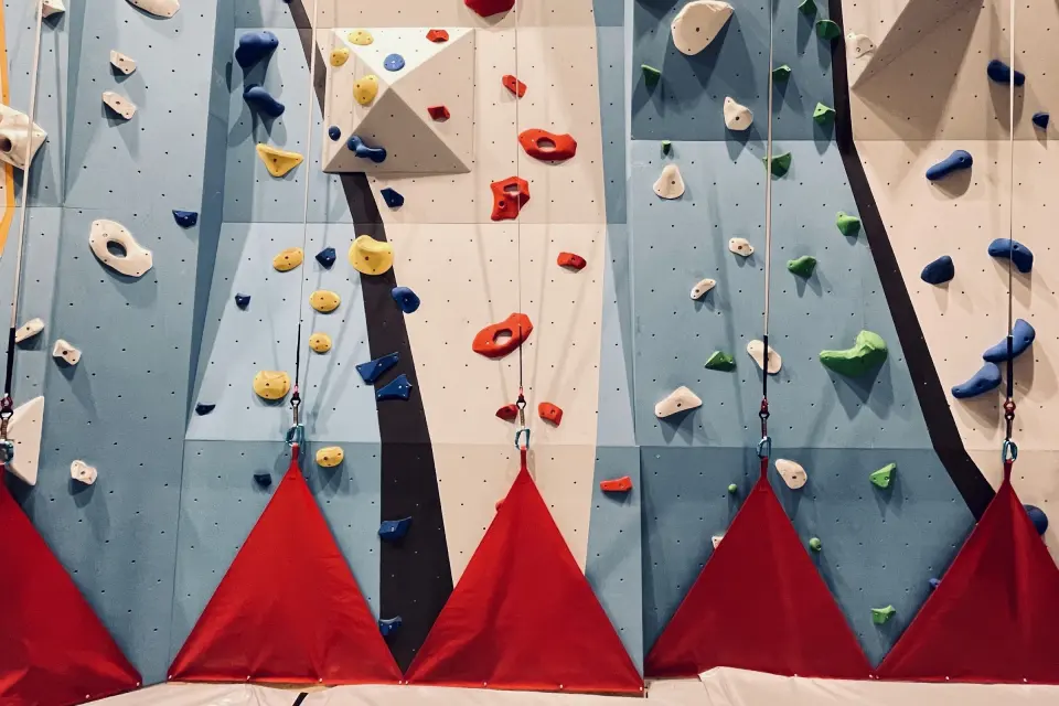 Auto-belay lanes on the 8 m climbing wall, with red padding at the foot of each lane