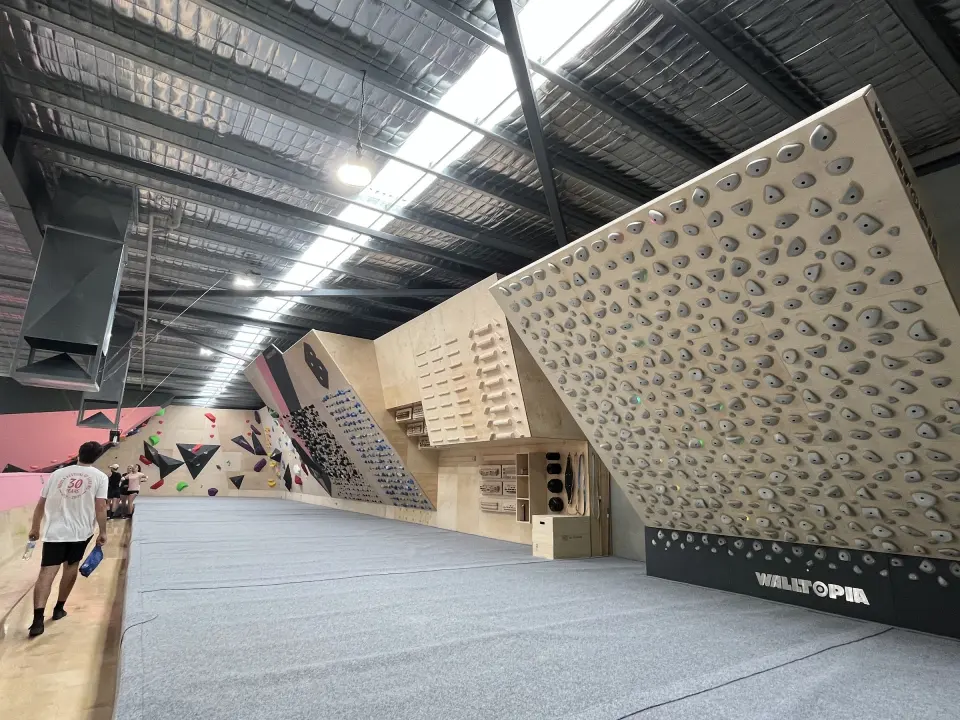 Overhanging board wall beside a long stretch of matting