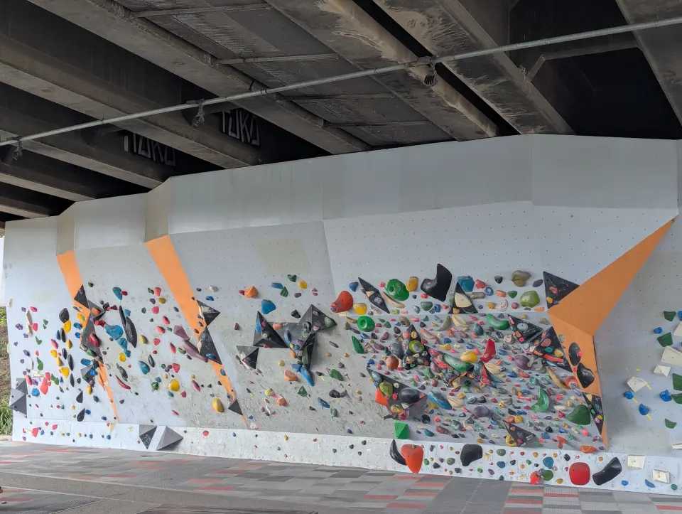 Bouldering wall with orange panels and a spray wall beneath the Hopkins Street bridge