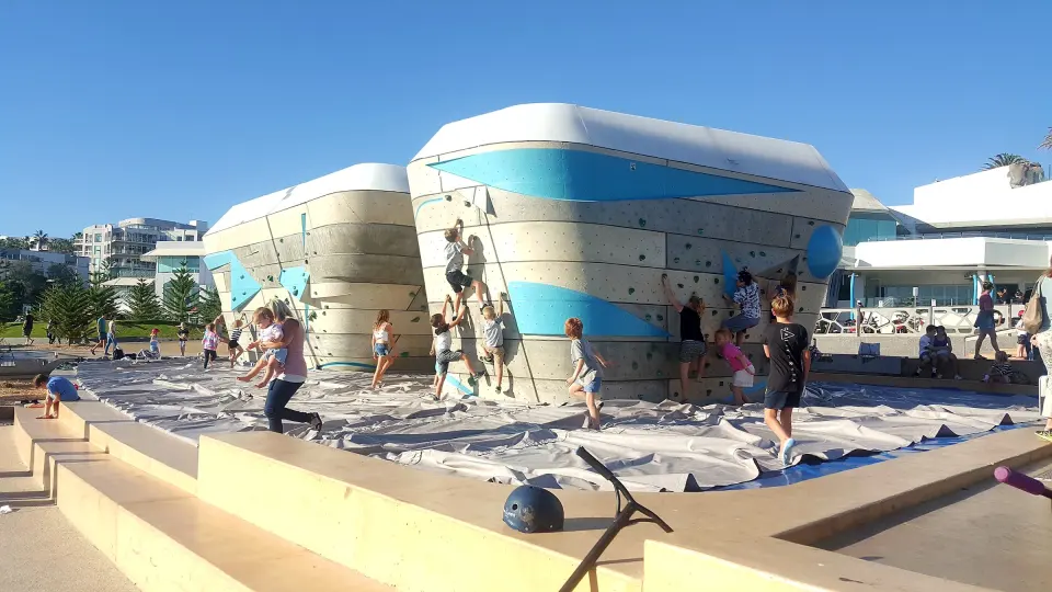 The sculpted bouldering wall on padded matting by Scarborough Beach on a sunny day