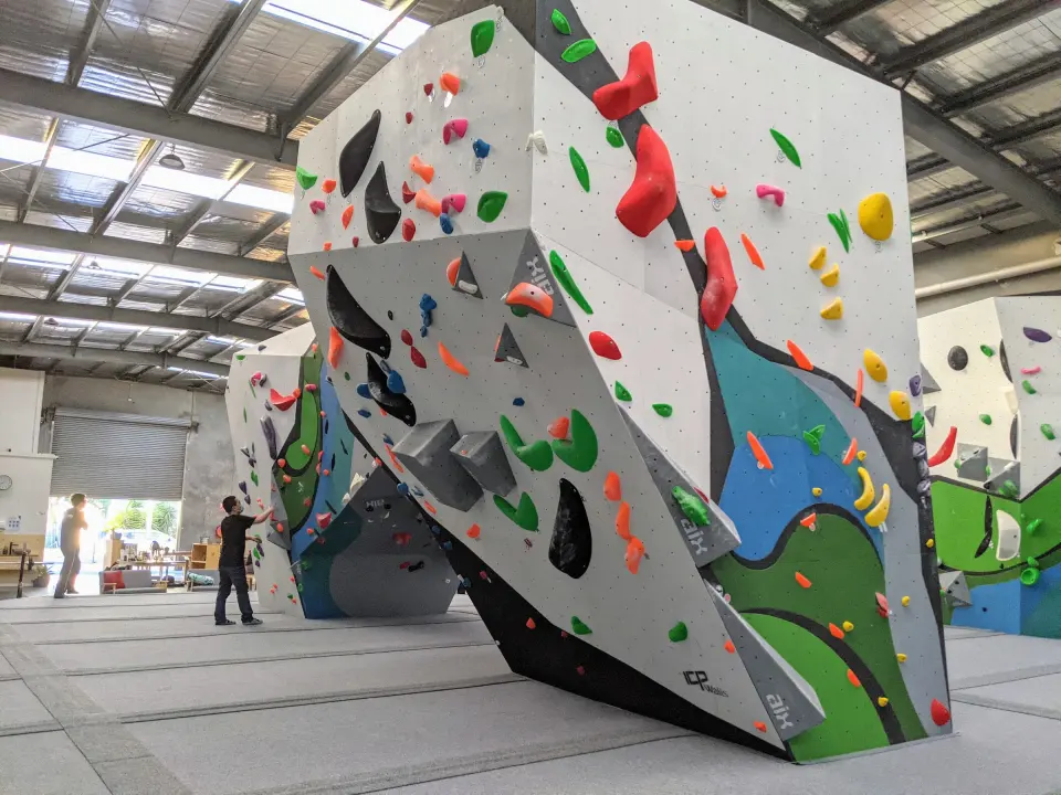 Freestanding bouldering block with overhanging faces and colourful holds