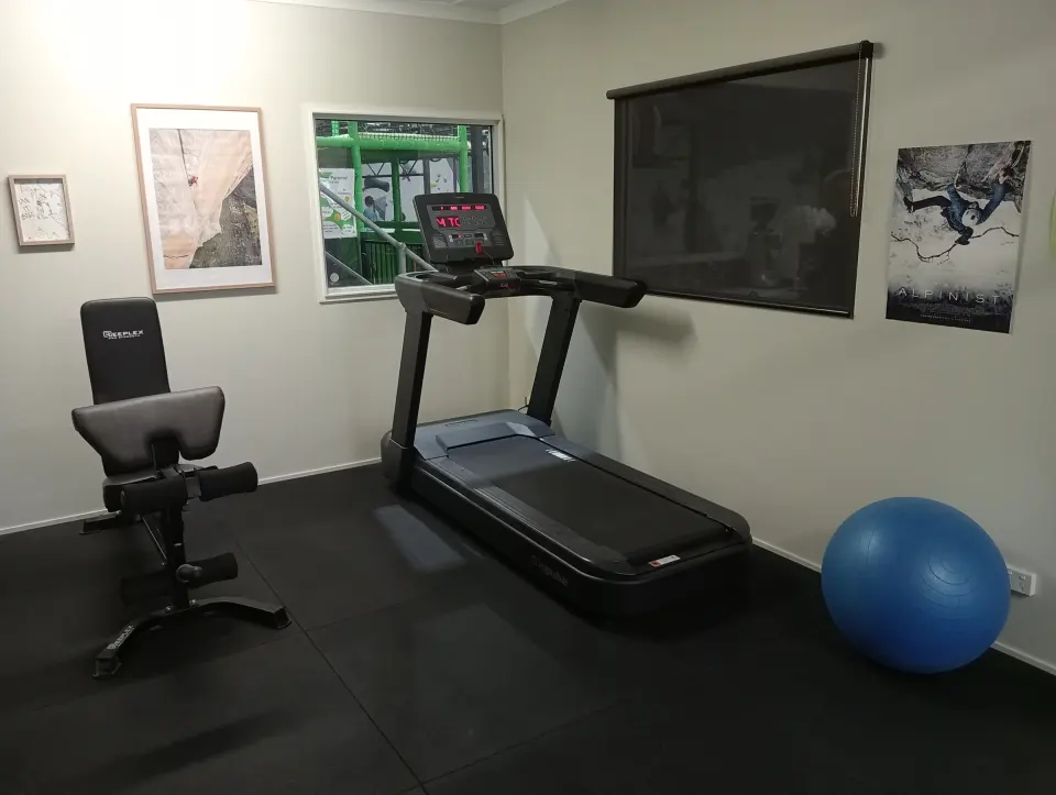 Gym room with a treadmill and weight bench