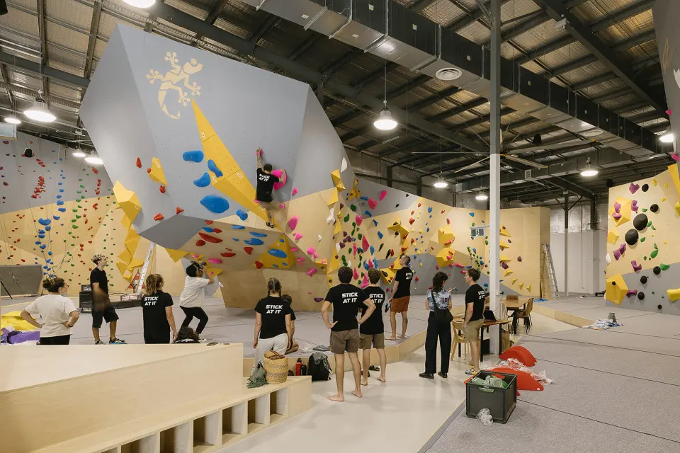 Bouldering hall with a large grey freestanding block and yellow volumes