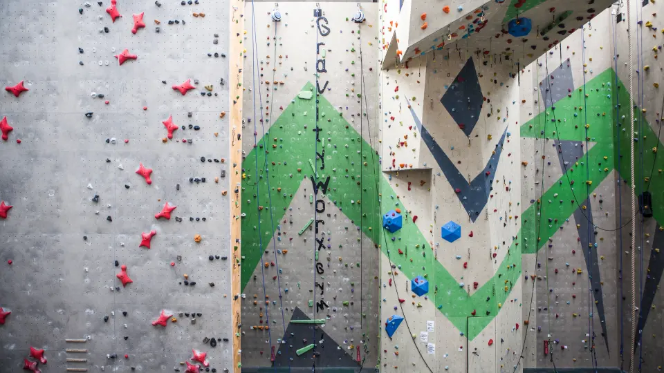 The IFSC speed lane beside tall lead walls painted with green chevrons and the Gravity Worx name