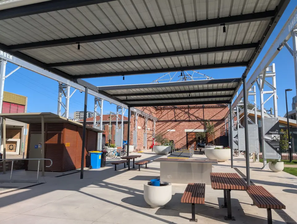 Sheltered barbecue and picnic area under a steel canopy in the park