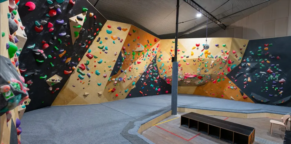 Boulderlounge's bouldering hall in Gympie, with wooden and black walls around blue matting
