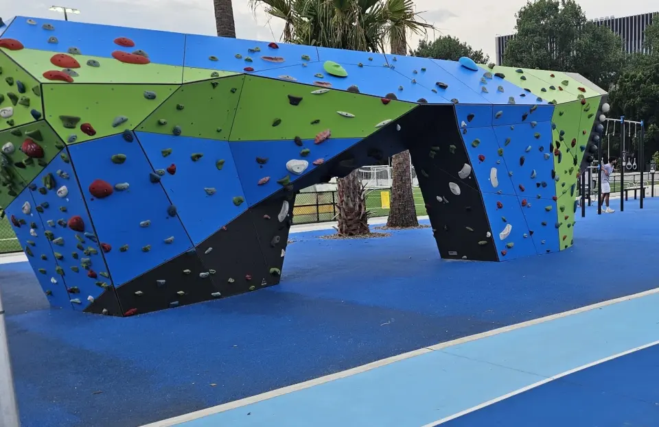 The bouldering wall's bridge arch beside the Village Green running track