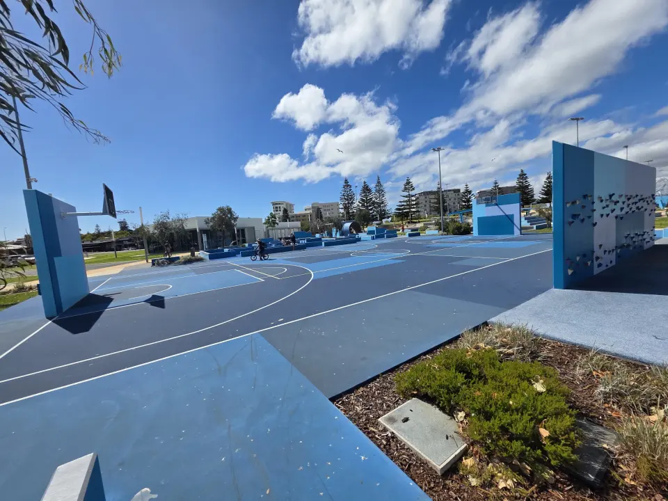 End of the climbing wall beside the blue multi-sports court