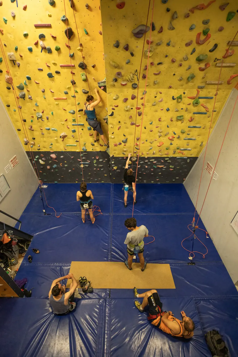 Looking down the climbing wall to belayers on the blue matting