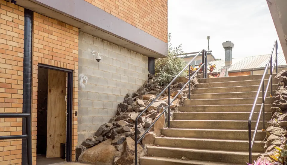 Steps down to the bouldering wall's door below J Block